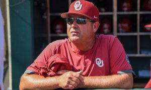 Jun 25, 2022; Omaha, NE, USA; Oklahoma Sooners head coach Skip Johnson looks over the field before the game against the Ole Miss Rebels at Charles Schwab Field. Mandatory Credit: Steven Branscombe-USA TODAY Sports