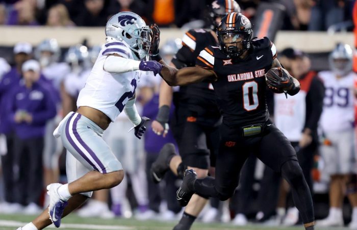 Oklahoma State's Ollie Gordon II (0) tries to get by Kansas State's Kobe Savage (2) in the first half of the college football game between the Oklahoma State University Cowboys and the Kansas State Wildcats at Boone Pickens Stadium in Stillwater. Okla., Friday, Oct. 6, 2023. OSU won 29-21.