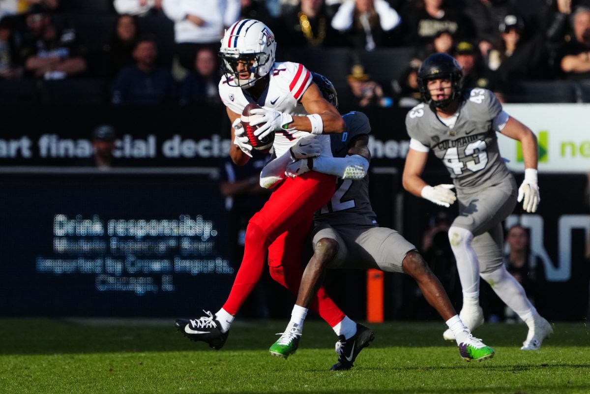 Nov 11, 2023; Boulder, Colorado, USA; Colorado Buffaloes cornerback Travis Hunter (12) tackles Arizona Wildcats wide receiver Tetairoa McMillan (4) in the second half at Folsom Field. Mandatory Credit: Ron Chenoy-USA TODAY Sports