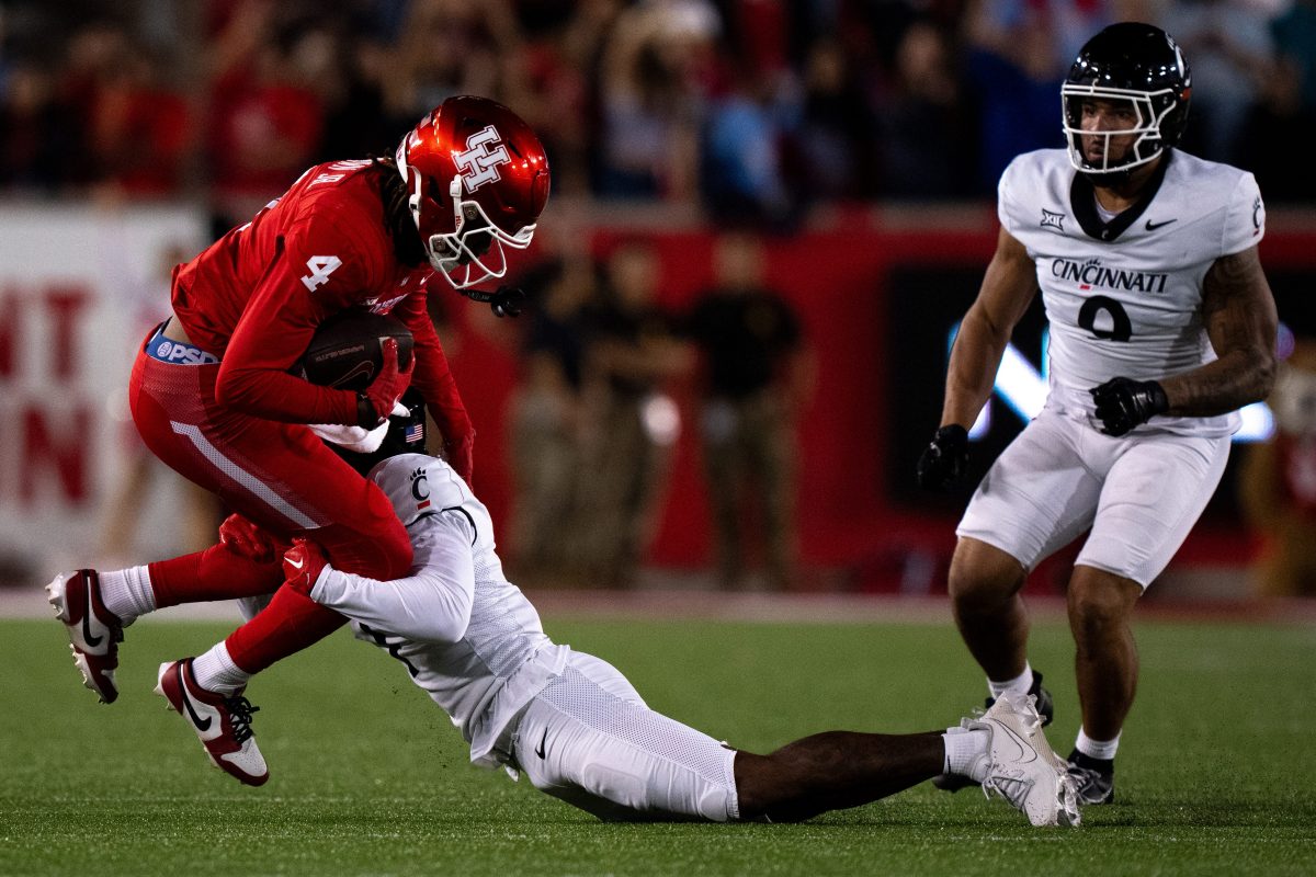 Cincinnati Bearcats cornerback Jordan Young (1) tackles Houston Cougars wide receiver Samuel Brown (4) in the fourth quarter of the NCAA football game between the Cincinnati Bearcats and the Houston Cougars TDECU Stadium in Houston, Texas, on Saturday, Nov. 11, 2023.