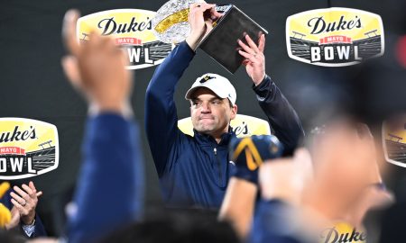 Dec 27, 2023; Charlotte, NC, USA; West Virginia Mountaineers head coach Neal Brown holds up the championship trophy after the game at Bank of America Stadium. Mandatory Credit: Bob Donnan-USA TODAY Sports