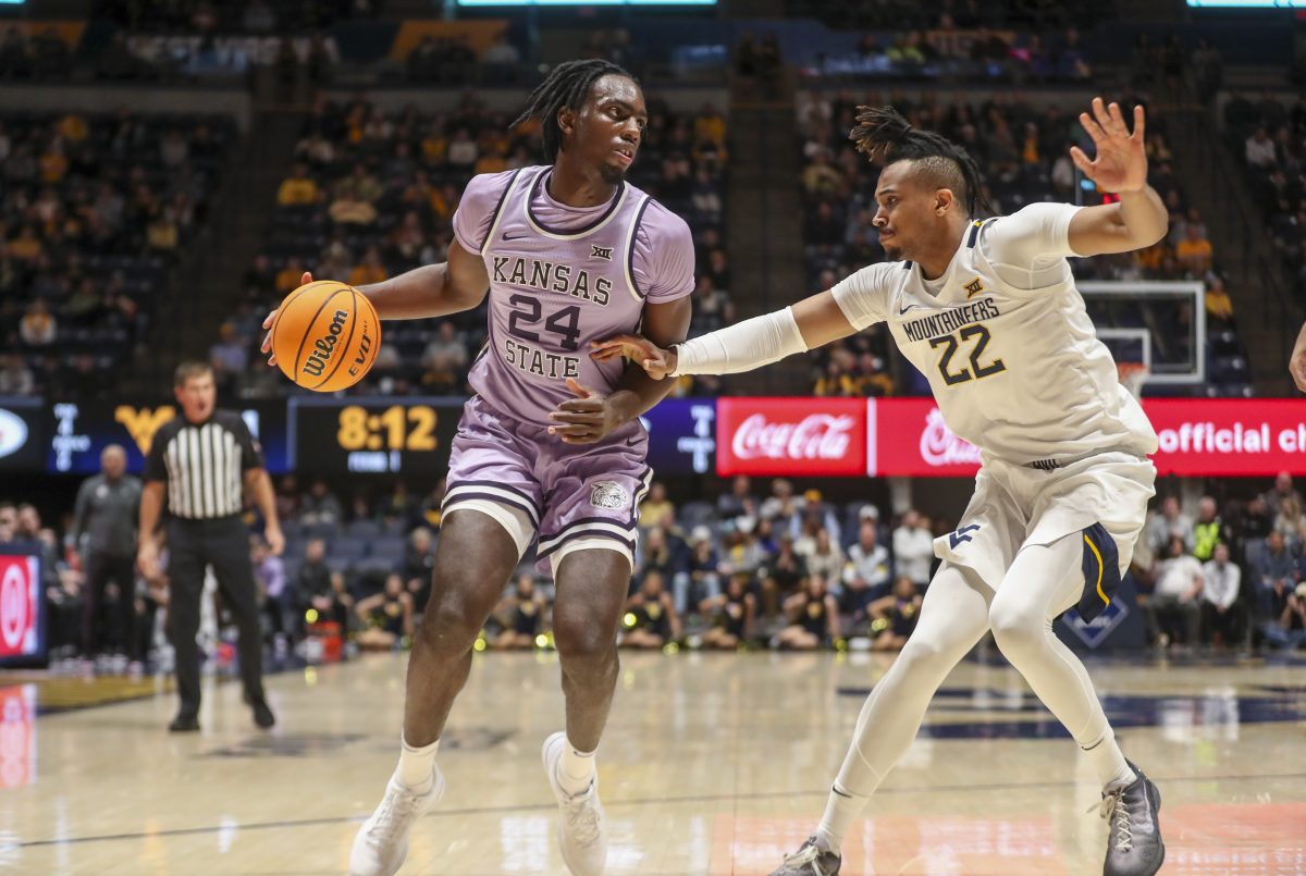 Jan 9, 2024; Morgantown, West Virginia, USA; Kansas State Wildcats forward Arthur Kaluma (24) dribbles against West Virginia Mountaineers forward Josiah Harris (22) during the first half at WVU Coliseum. Mandatory Credit: Ben Queen-USA TODAY Sports