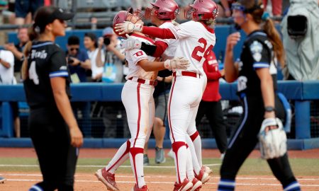 Oklahoma's Alyssa Brito (33), Tiare Jennings (23) and Jayda Coleman (24) celebrate as Duke's Ana Gold (4) and Dani Drogemuller (16) walk of the field following the Women's College World Series game between Alabama and UCLA at Devon Park in Oklahoma City, Thursday, May, 30, 2024.