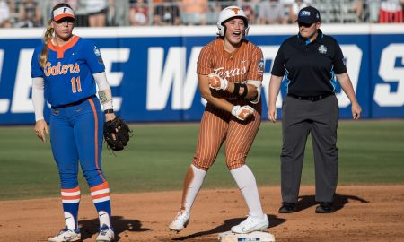 Jun 1, 2024; Oklahoma City, OK, USA; Texas Longhorns utility Katie Stewart (20) yells after hitting a double as Florida Gators infielder Mia Williams (11) looks on in the first inning during a Women's College World Series softball winners bracket game at Devon Park. Mandatory Credit: Brett Rojo-USA TODAY Sports