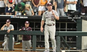 Jun 24, 2024; Omaha, NE, USA; Texas A&M Aggies head coach Jim Schlossnagle signals the umpire against the Tennessee Volunteers during the ninth inning at Charles Schwab Field Omaha. Mandatory Credit: Steven Branscombe-USA TODAY Sports